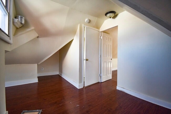 A room with a wooden floor and a white door.