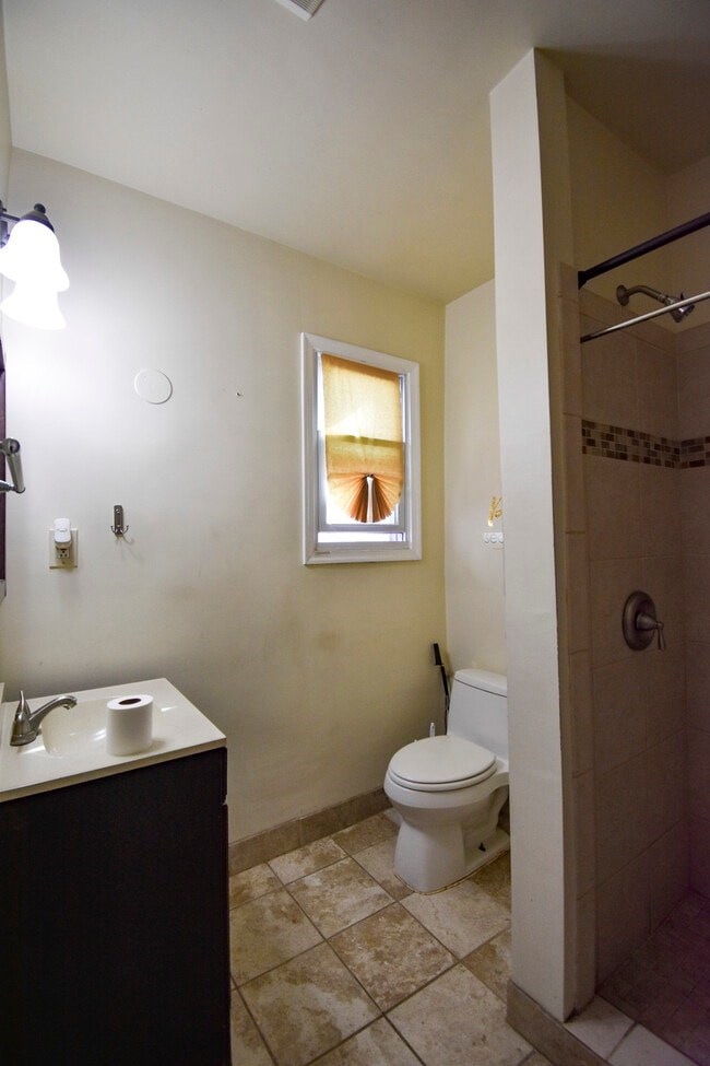 A bathroom with a toilet, sink, and shower.