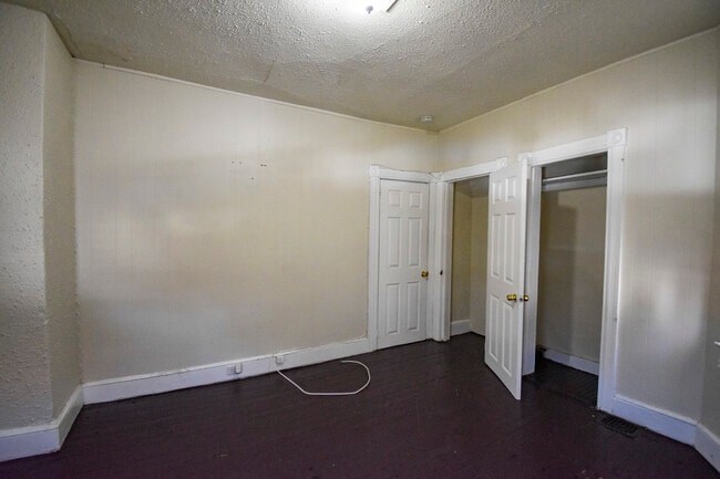 A room with two doors and a white wall.