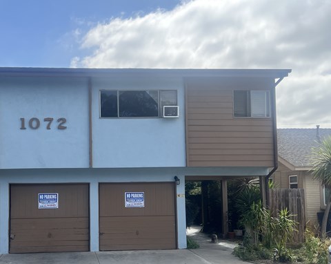 A two-story building with garage doors that say no parking.