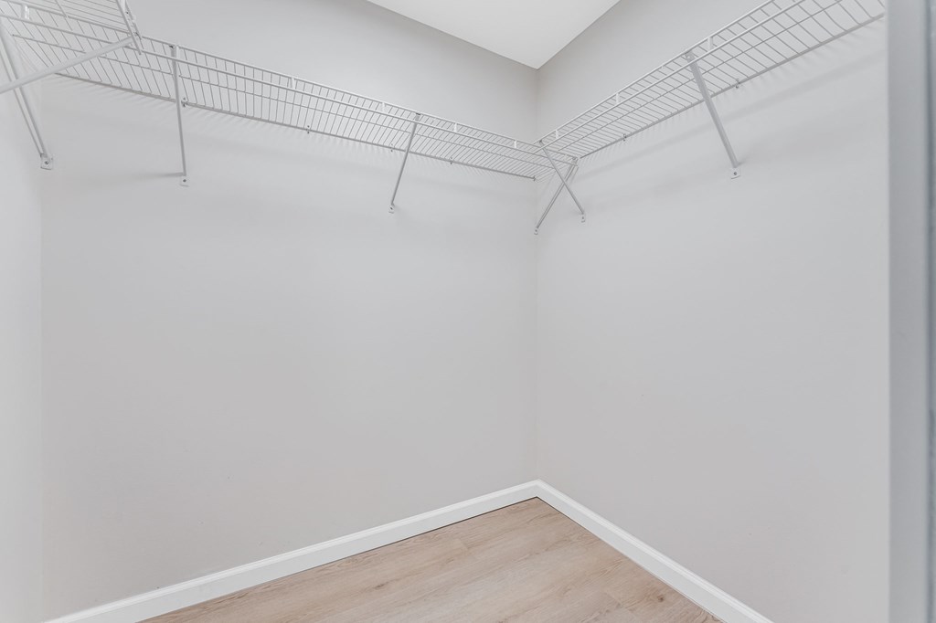 Empty room with a white wall and a wooden floor.