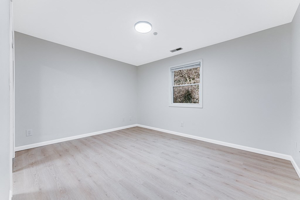 A room with a picture on the wall and a window.