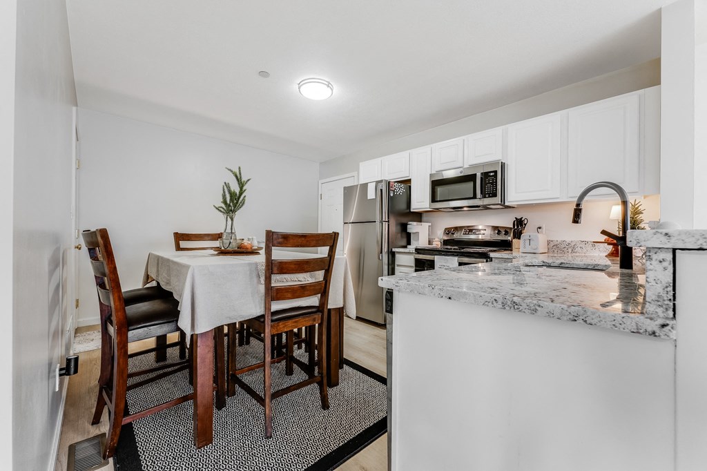 A kitchen with a table and chairs.