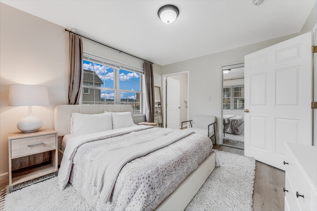 A bedroom with a large bed and a window with curtains.
