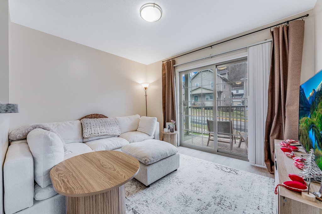 A living room with a white couch and a wooden coffee table.