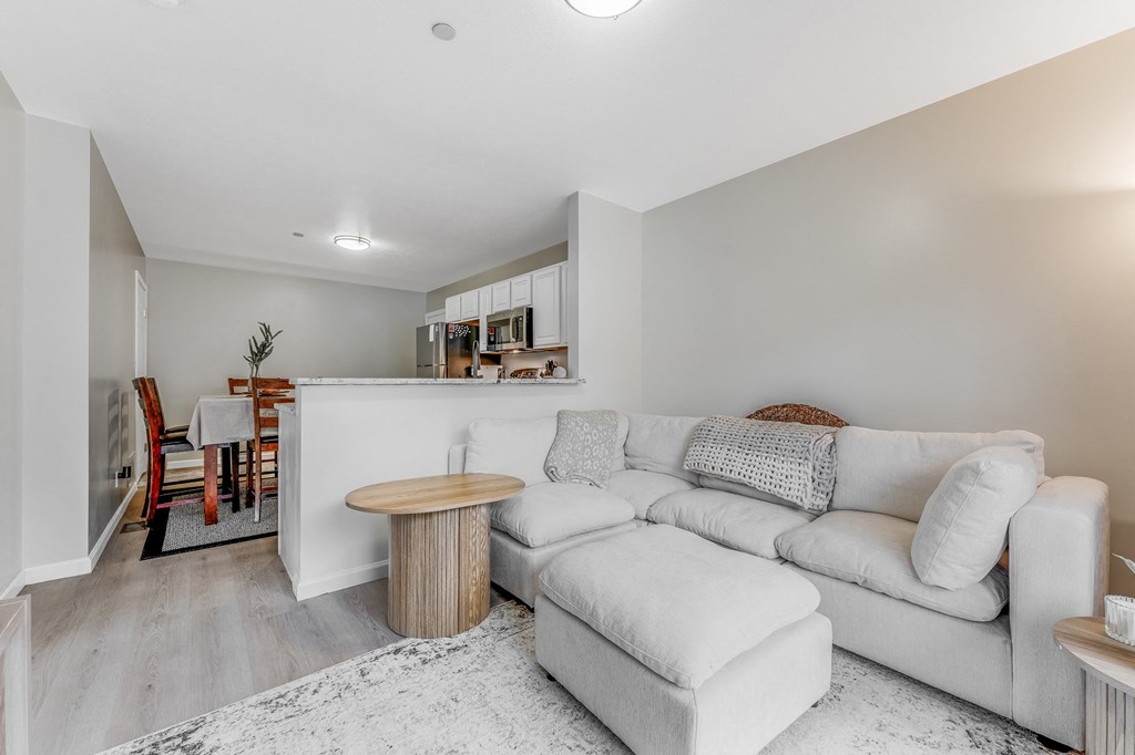 A living room with a white couch and a wooden table.