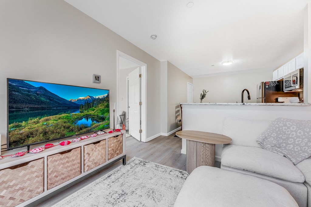 A modern living room with a flat screen TV and a white couch.