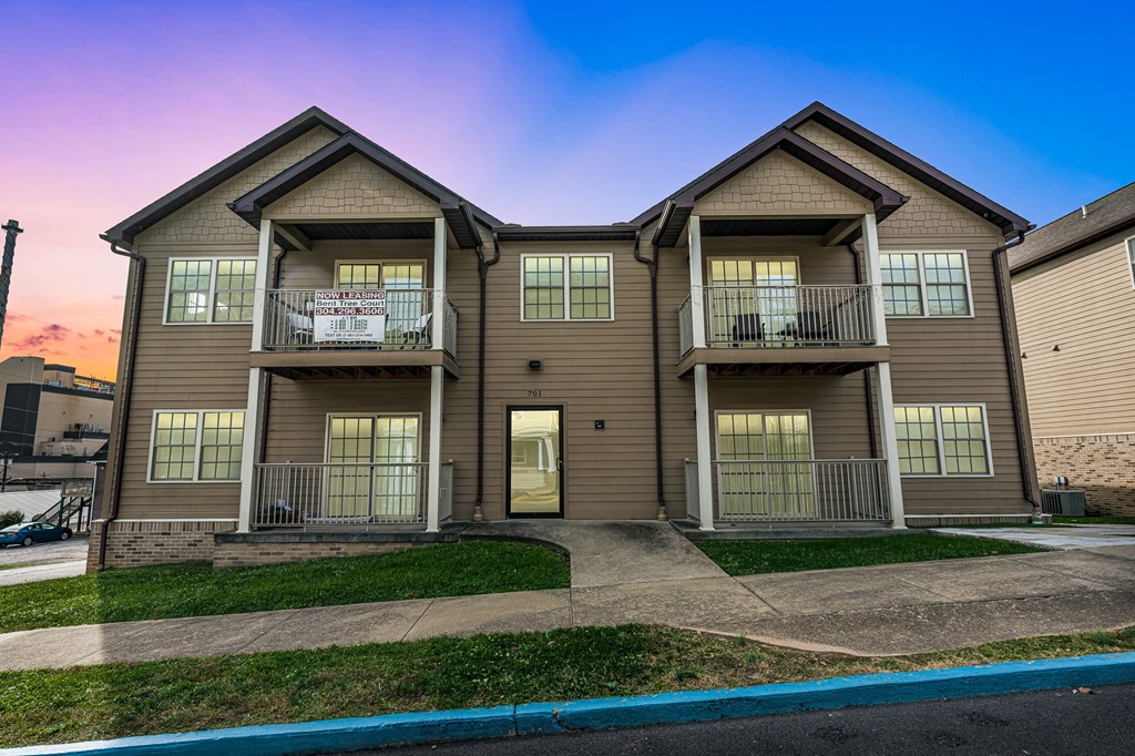 A two-story apartment building with a balcony on the second floor.