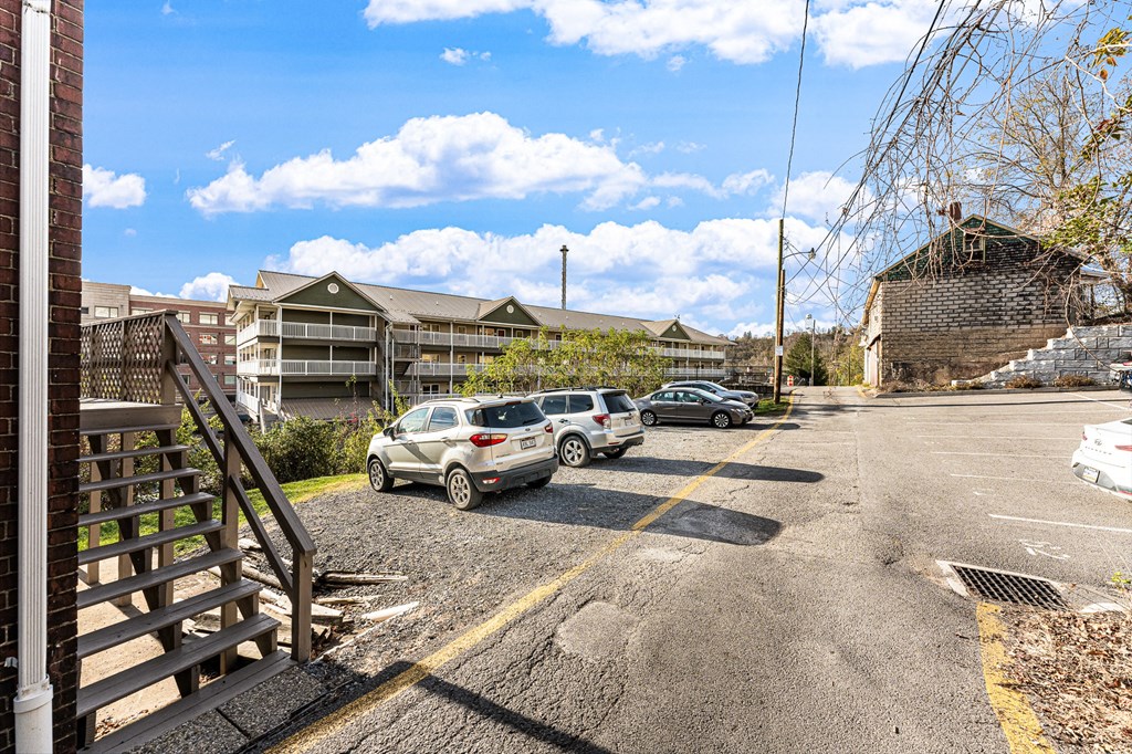A parking lot with cars and a building in the background.