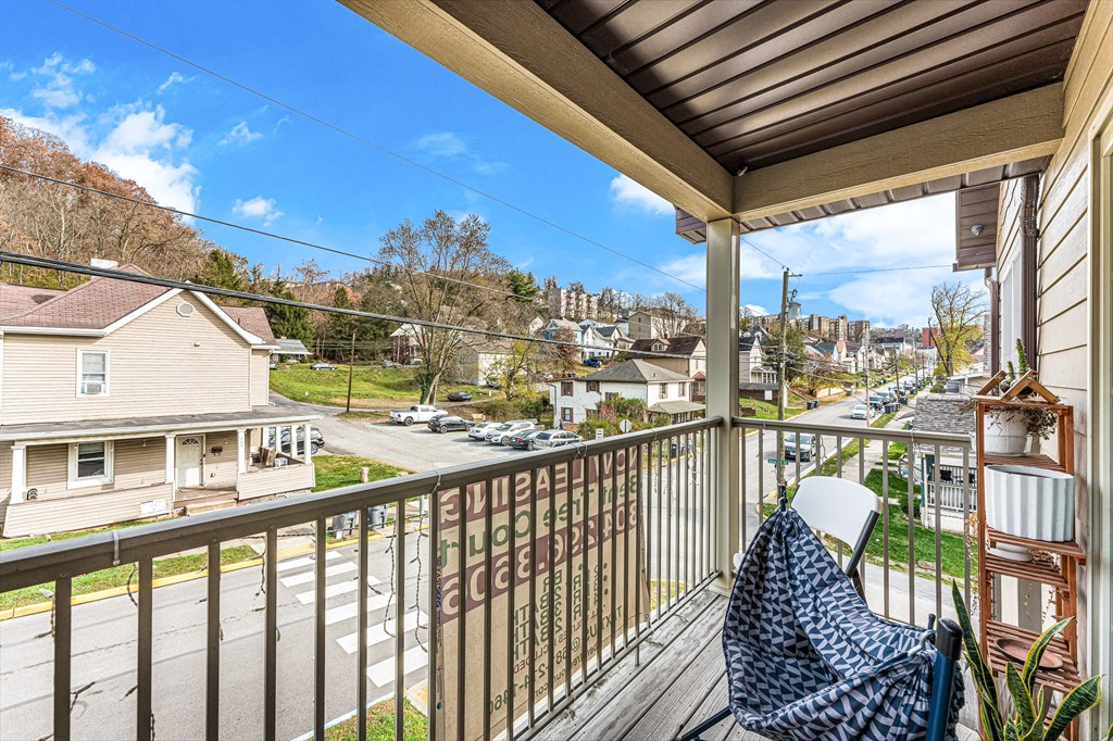A balcony with a chair and a table with a potted plant on it.