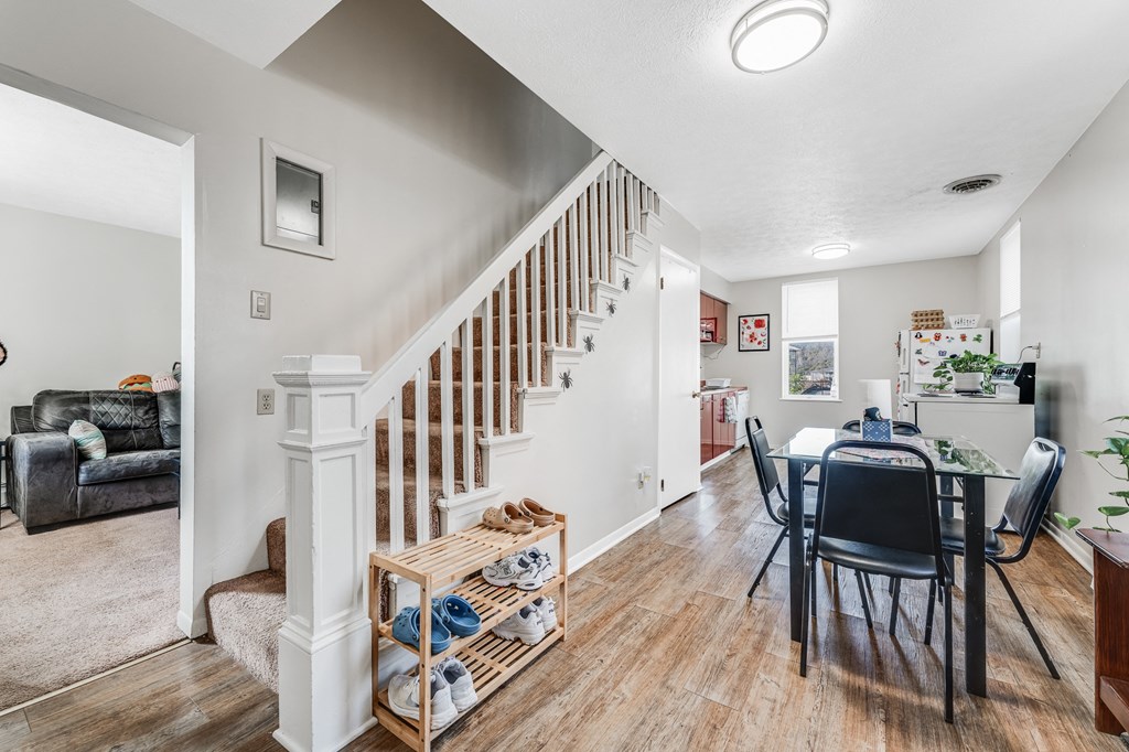 A room with a staircase and a dining table.
