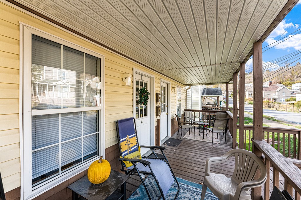 A yellow pumpkin sits on a table on a porch.