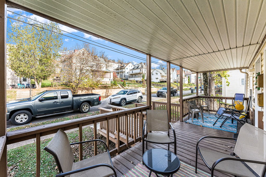 A patio with a table and chairs overlooking a street.