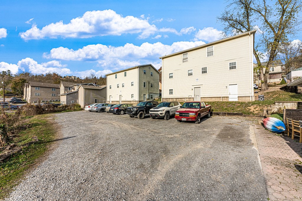 A parking lot with several cars and a white building in the background.