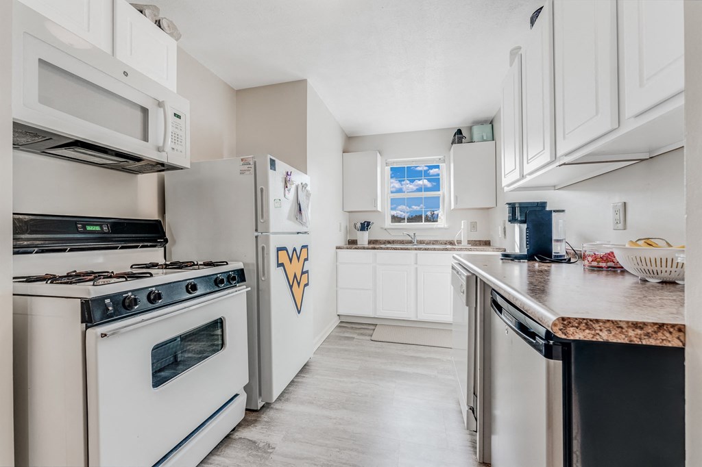 A kitchen with a stove, oven, and microwave.