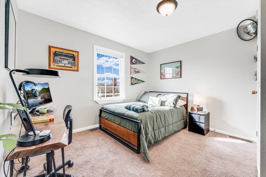 A bedroom with a bed, desk, and chair.