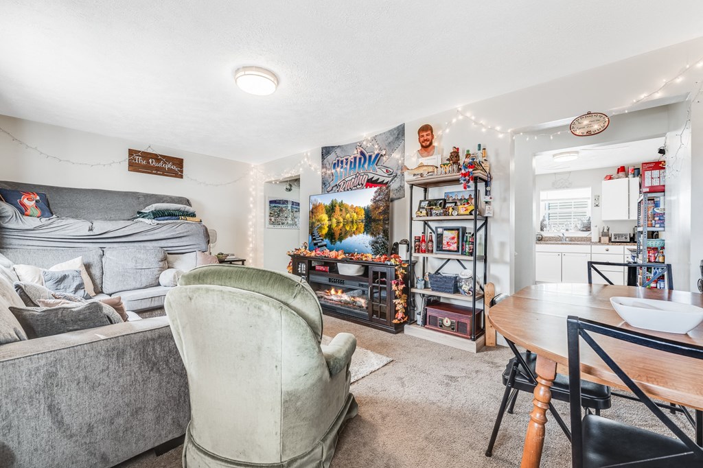 A grey couch sits in a living room with a chair and a table.