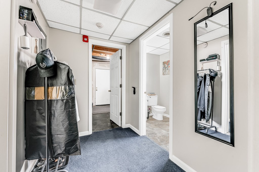 A hallway with a coat rack and a mirror.