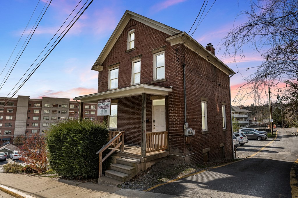 A red brick house with a porch.