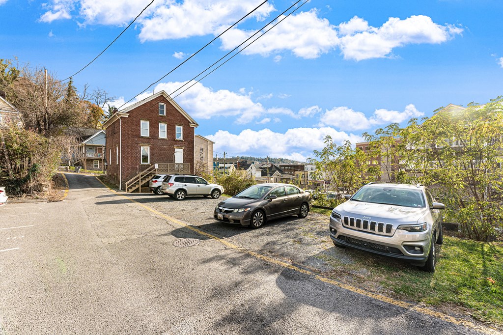 A parking lot with a building and cars.