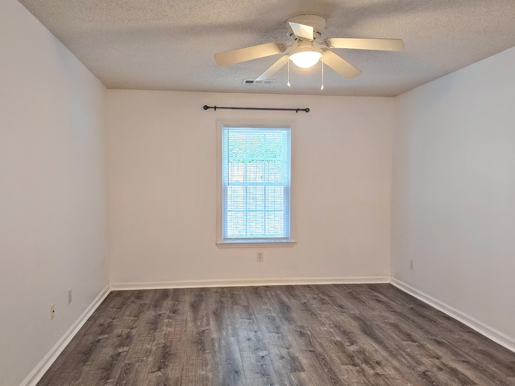 an empty room with white walls and a ceiling fan