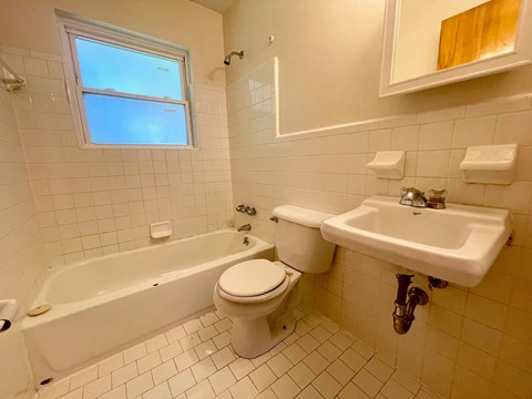 a bathroom with a toilet and a sink and a bath tub