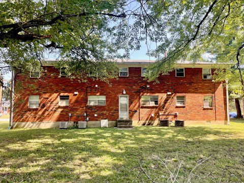 an old brick building with trees in front of it