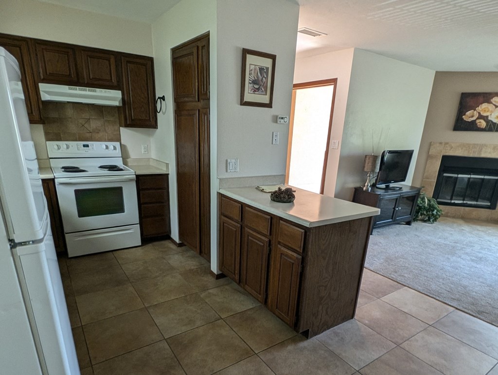 a kitchen with an island and a stove and a fireplace