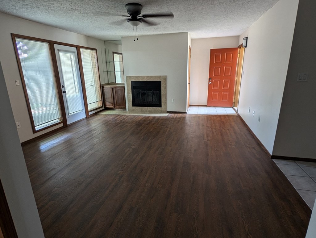 an empty living room with wood floors and a fireplace