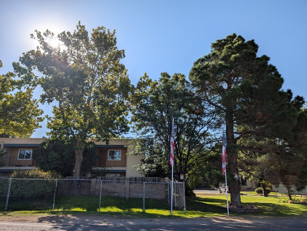 a house with a fence and trees in front of it
