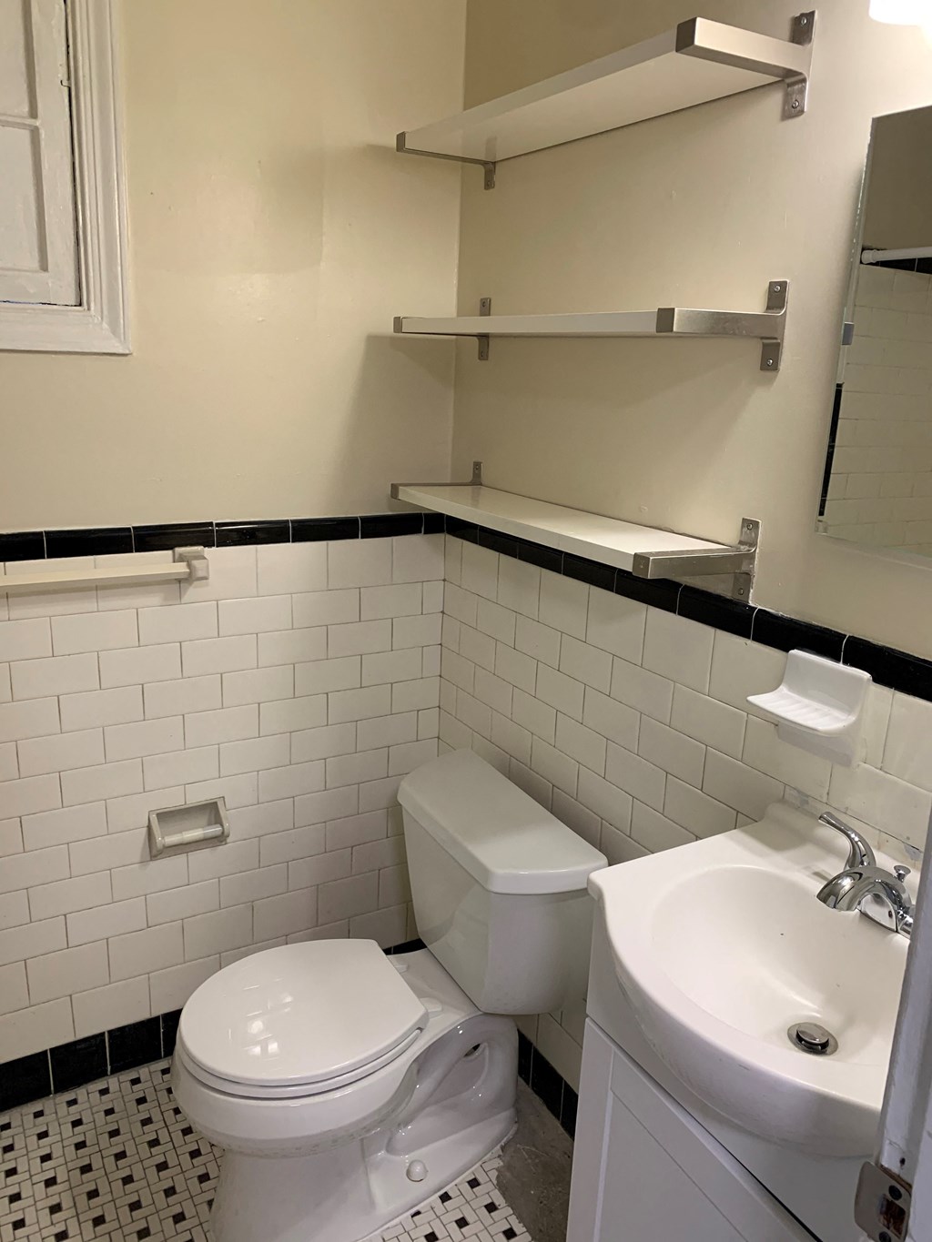 A white toilet and sink in a bathroom.