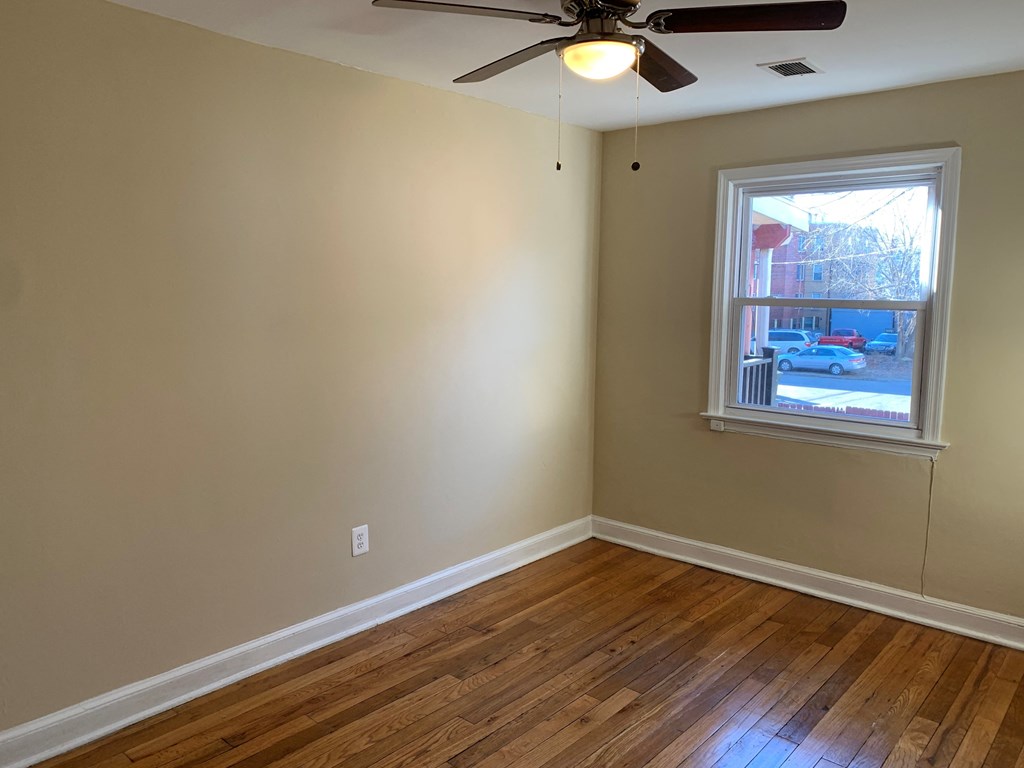 A room with a ceiling fan and a window.