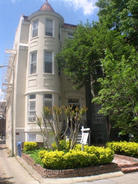 A large white building with a tower and a fire escape.