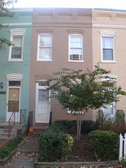 the front of a brick house with a white door