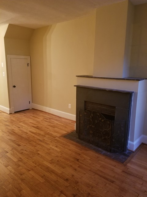 a living room with a fireplace and a wooden floor