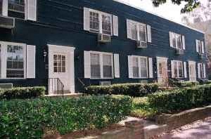 A row of houses with white windows and shutters.