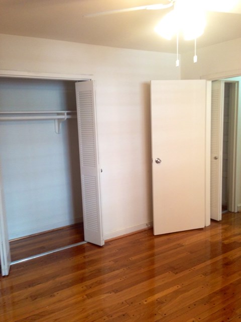 an empty living room with a closet and a hard wood floor