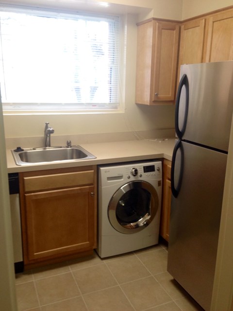 a small kitchen with a washing machine and a sink