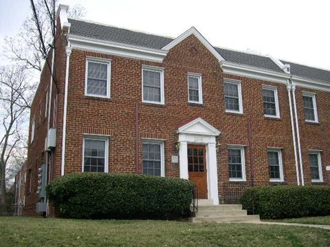 A red brick building with a white door and windows.