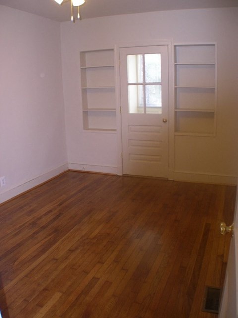 A room with a white door and shelves.