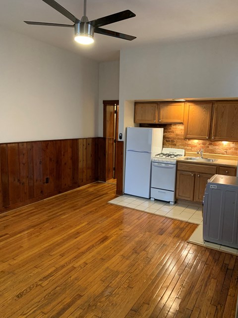 A kitchen with wooden floors and white appliances.
