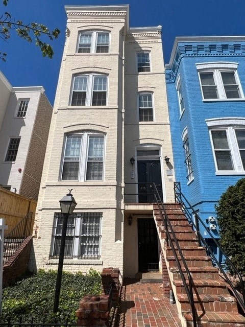 A white building with a black lamp post in front of it.