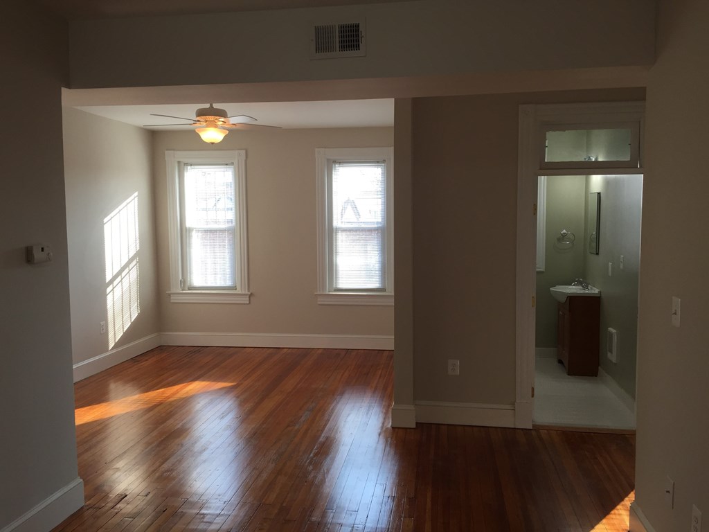 A room with wooden floors and a ceiling fan.