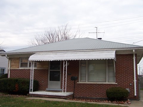 A house with a red brick exterior and a white porch.