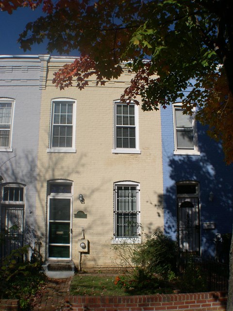 A row of three houses with different colored siding.
