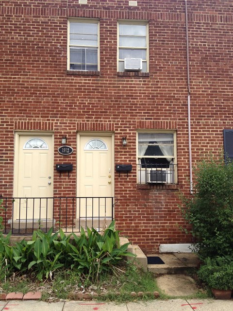 A red brick building with a white door and windows.