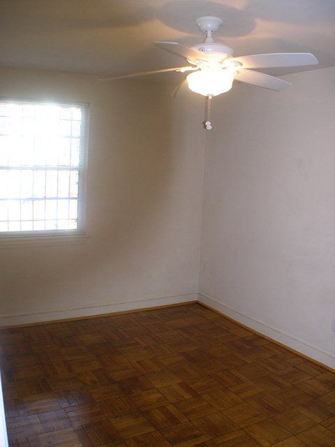A room with a ceiling fan and a window.