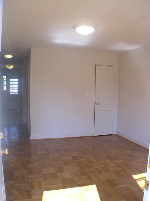 A room with a wooden floor and a white door.