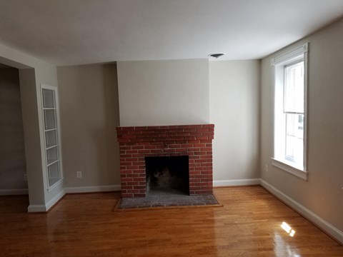 A room with a fireplace and wooden floors.