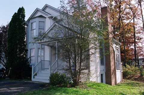 A house with a grey facade and a white door.